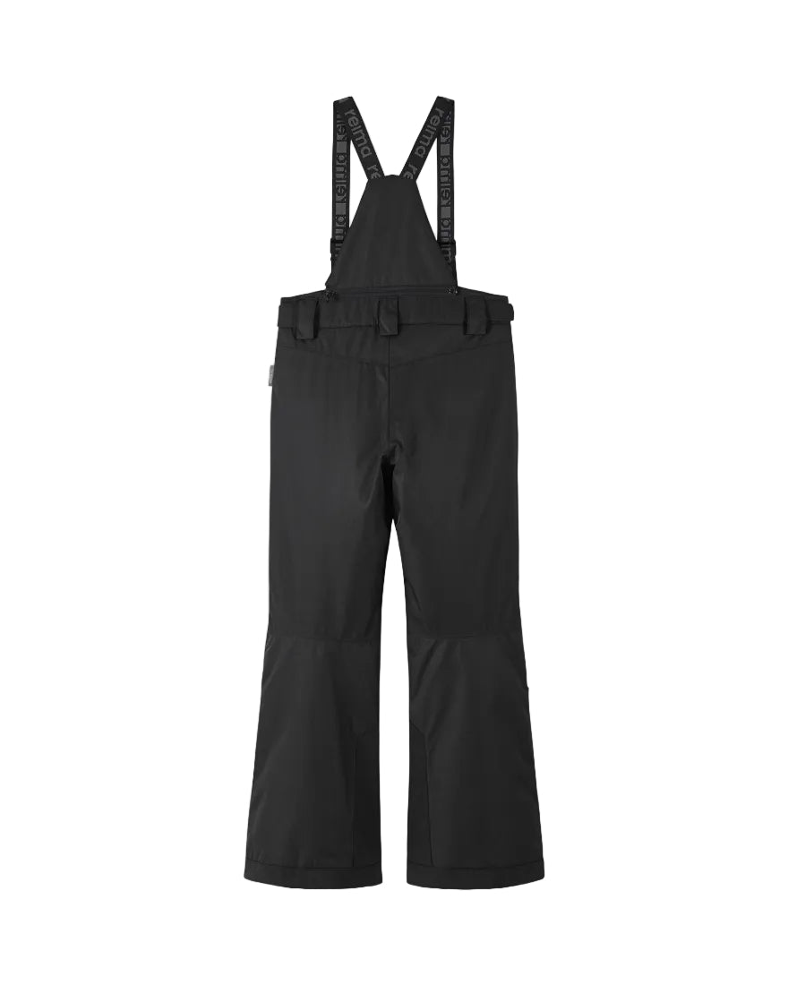 Rear view of black Reima Jr Terrie Pants featuring a waterproof Reimatec shell, detachable elastic suspenders, reinforced ankle scuff guards, and internal snow gaiters.