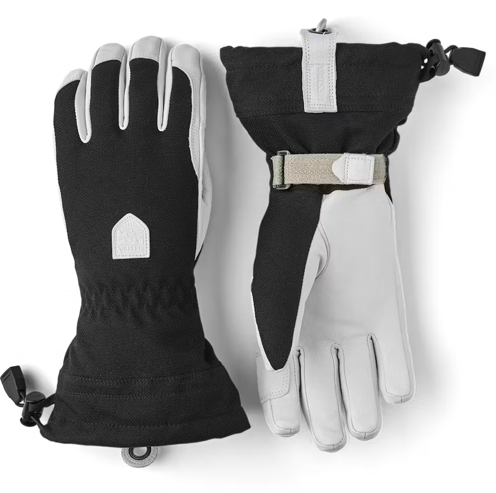 A pair of black and white Hestra Women’s Patrol Gauntlet Gloves, which are designed to keep your hands warm and dry in harsh winter conditions.