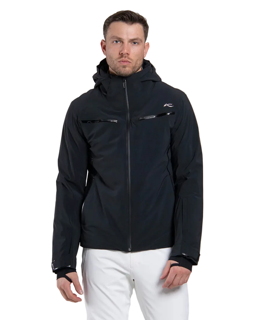 Front view of a black Kjus Men’s Formula Jacket featuring 4-way stretch waterproof fabric, Fast Thermo Core insulation, water-repellent zippers, AC-Vent forearm ports, and a detachable helmet-compatible hood.