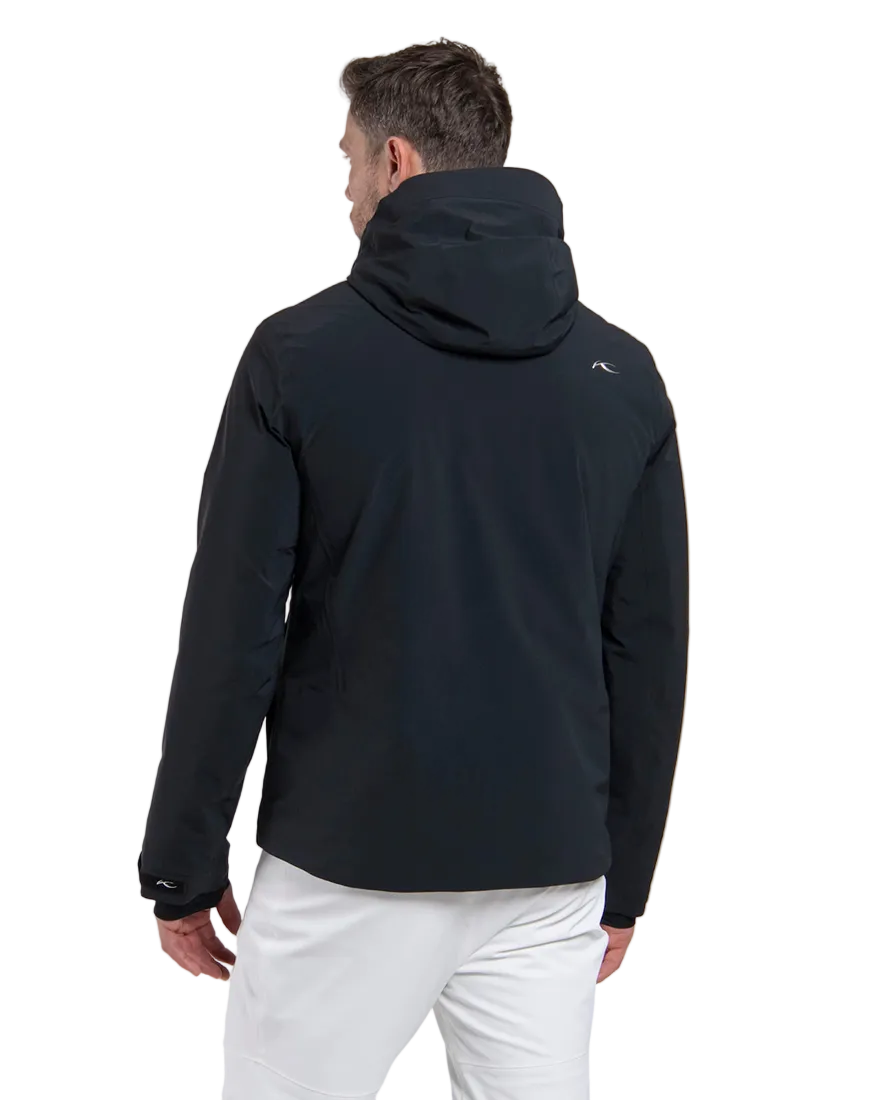 Rear view of a black Kjus Men’s Formula Jacket featuring 4-way stretch waterproof fabric, Fast Thermo Core insulation, water-repellent zippers, AC-Vent forearm ports, and a detachable helmet-compatible hood.