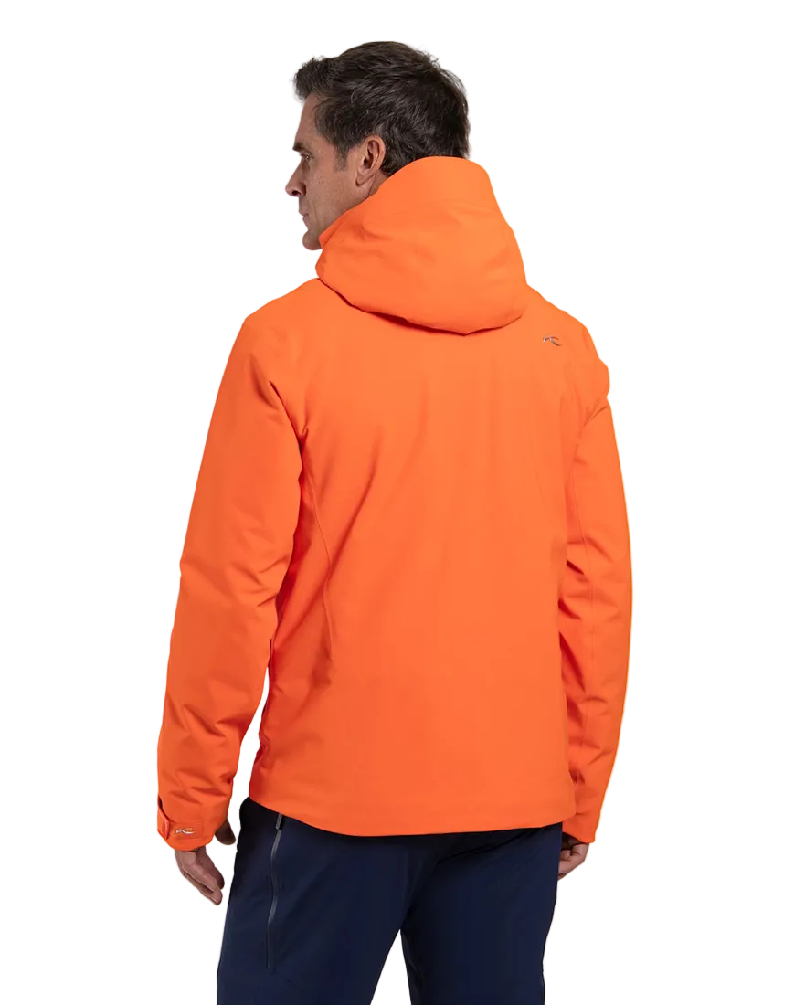 Rear view of an orange Kjus Men’s Formula Jacket featuring 4-way stretch waterproof fabric, Fast Thermo Core insulation, water-repellent zippers, AC-Vent forearm ports, and a detachable helmet-compatible hood.