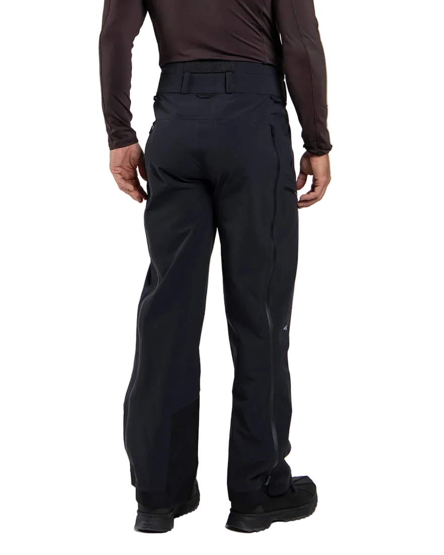 Rear view of black Kjus Men’s FRX Lucas Shell Pants featuring 3-layer waterproof stretch fabric, zippered outer thigh vents, water-repellent zippers, and Schoeller Keprotec reinforced scuff guards.