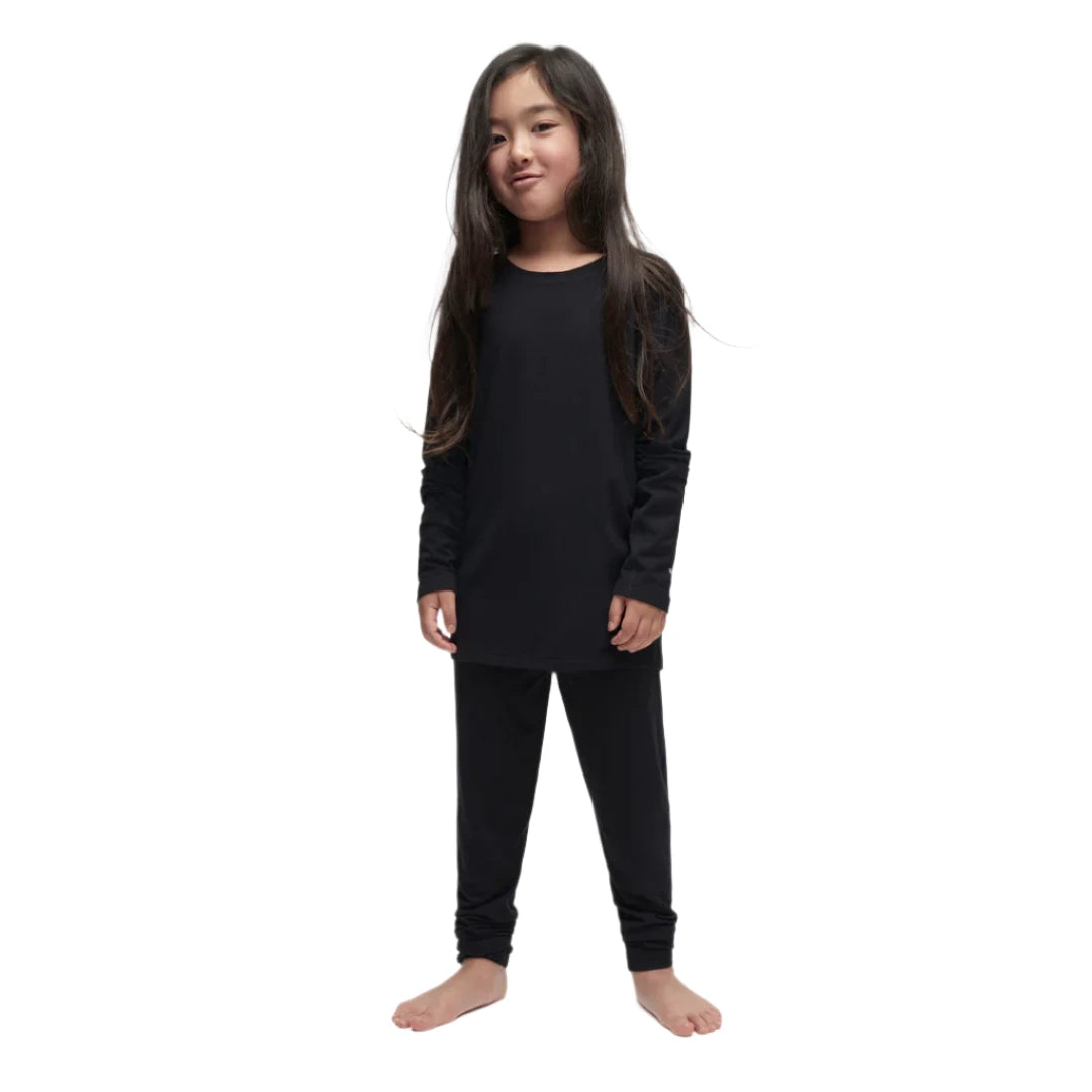 A child wearing a black Le Bent Kids' Core Midweight Raglan Crew Baselayer Top that is stretchable, breathable, and made from a premium bamboo and merino wool blend.
