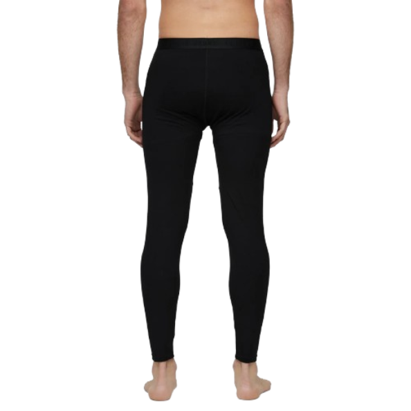 A man wearing a pair of Le Bent Men's Core Midweight Baselayer Bottoms that are made with a bamboo and merino wool blend.