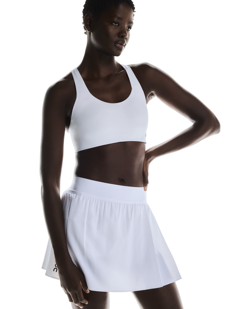 On Women's Court Pleated Skirt featuring lightweight performance fabric, pleated styling, built-in shorts, and athletic comfort.