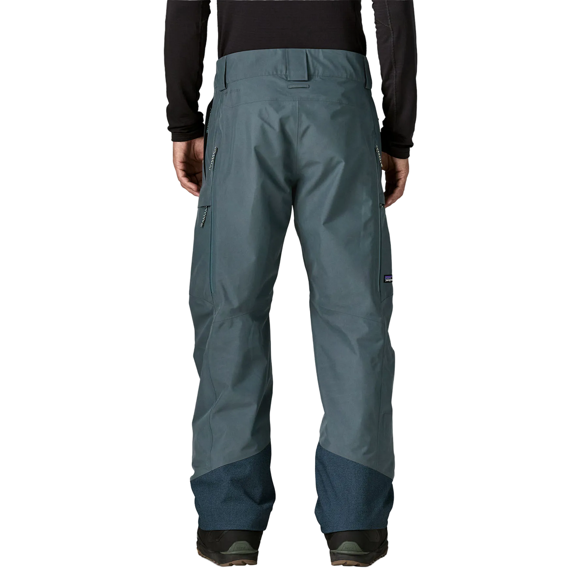 Rear view of the Patagonia Men's Storm Shift Pants featuring a 2-layer GORE-TEX shell made from 100% recycled polyester, a body-mapped zig-zag fleece and mesh lining, outer thigh ventilation zips with mesh backing, adjustable waist tabs with belt loops, dual zippered thigh pockets, scuff guards at the inner ankles, internal gaiters with gripper elastic, and an embedded RECCO reflector.