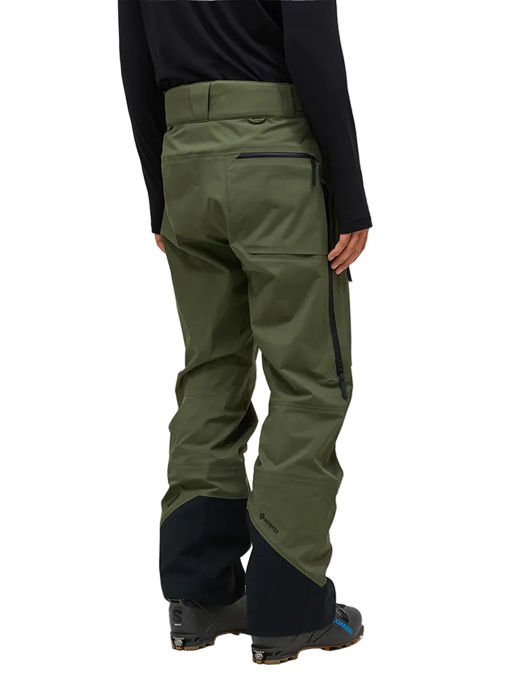 Rear view of the pine needle green Peak Performance Men's GORE-TEX C-Knit 3L Shell Pants featuring 3-layer GORE-TEX fabric with C-KNIT backer technology, YKK AquaGuard leg ventilation zips, an adjustable velcro waistband, and reinforced Cordura lower leg scuff guards.