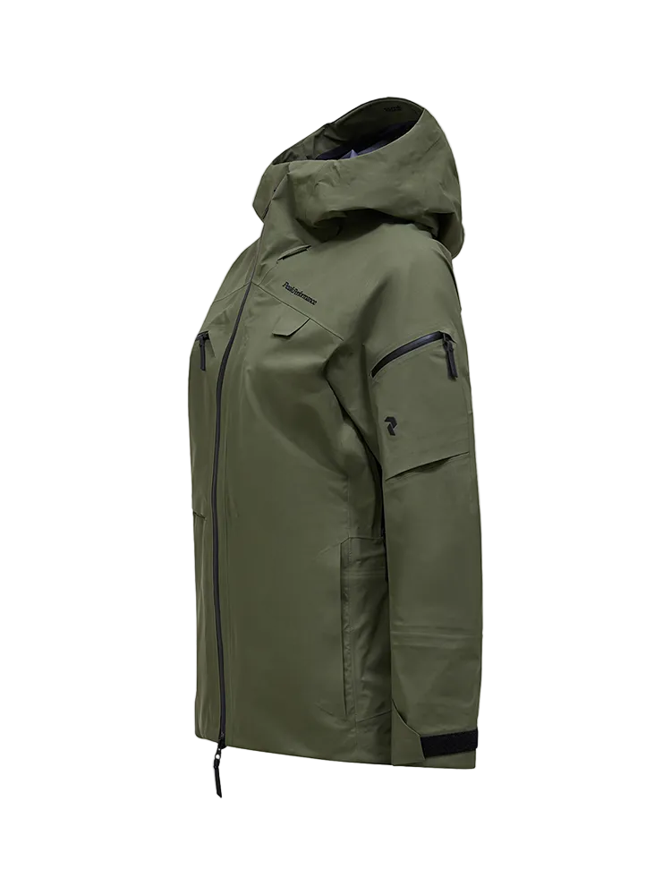 Side view of a pine needle green Peak Performance Women's Alpine GORE-TEX C-Knit 3L Shell Jacket featuring 3-layer GORE-TEX fabric with C-KNIT backer technology, YKK AquaGuard zippers, a 2-way adjustable helmet-compatible hood, and two-way underarm pit zips.