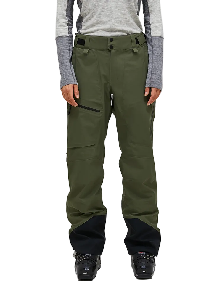 Front view of the pine needle green Peak Performance Women's Alpine GORE-TEX C-Knit 3L Shell Pants featuring 3-layer GORE-TEX fabric with C-KNIT backer technology, YKK AquaGuard leg ventilation zips, an adjustable velcro waistband, and reinforced Cordura lower leg scuff guards.