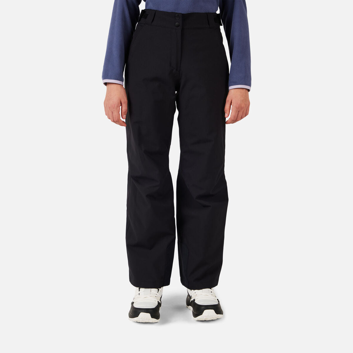 A girl wearing a pair of black Rossignol Girls' Insulated Ski Pants that are waterproof, breathable, stretchable, and warm.