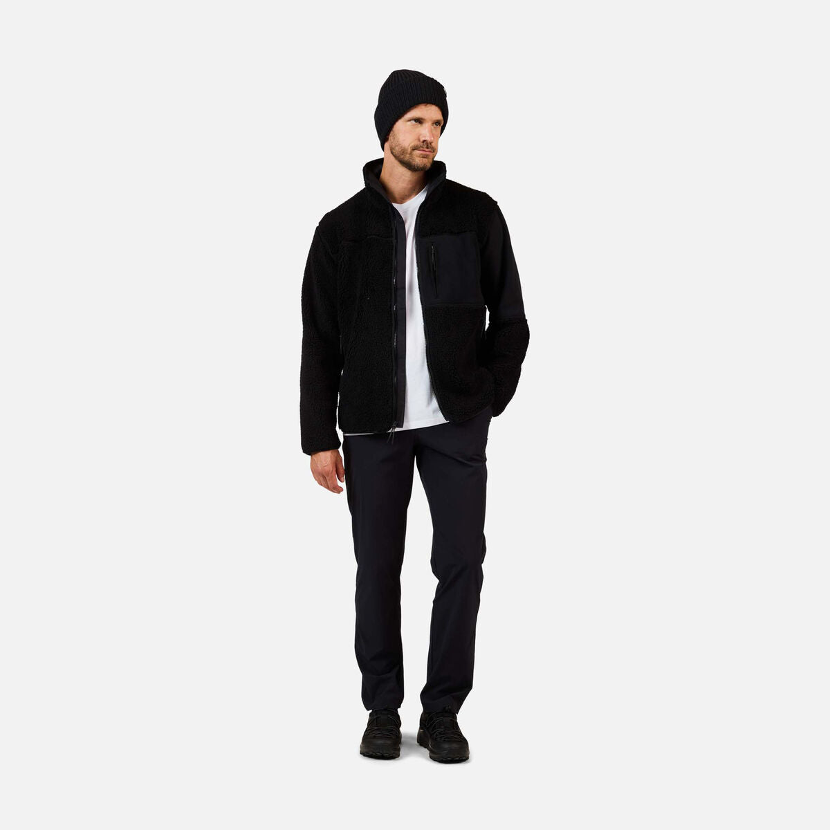 A man wearing a black Rossignol Men's All Track Snap Sherpa Jacket that is moisture-wicking, quickdrying, and warm.