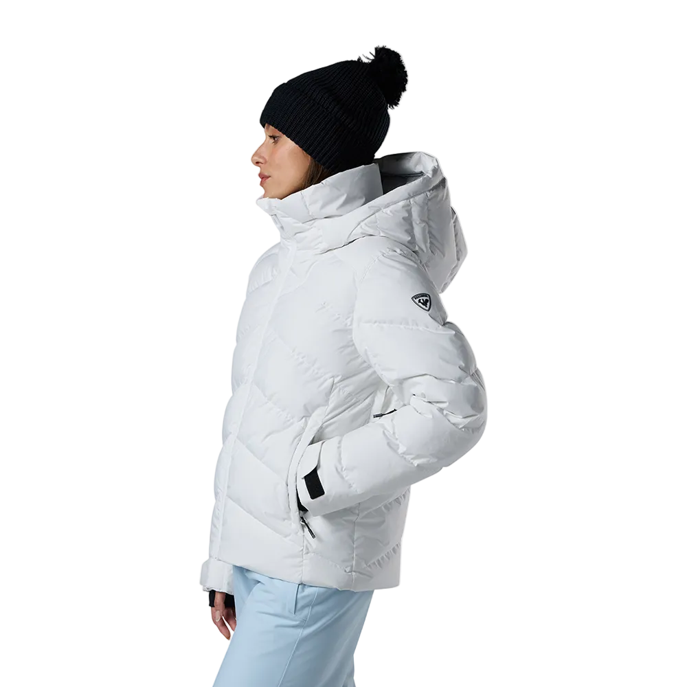 Side view of a white Rossignol Women’s Wispile Ripstop Down Jacket featuring high-loft baffled down insulation, durable ripstop outer fabric, insulated hood, and zippered handwarmer pockets.