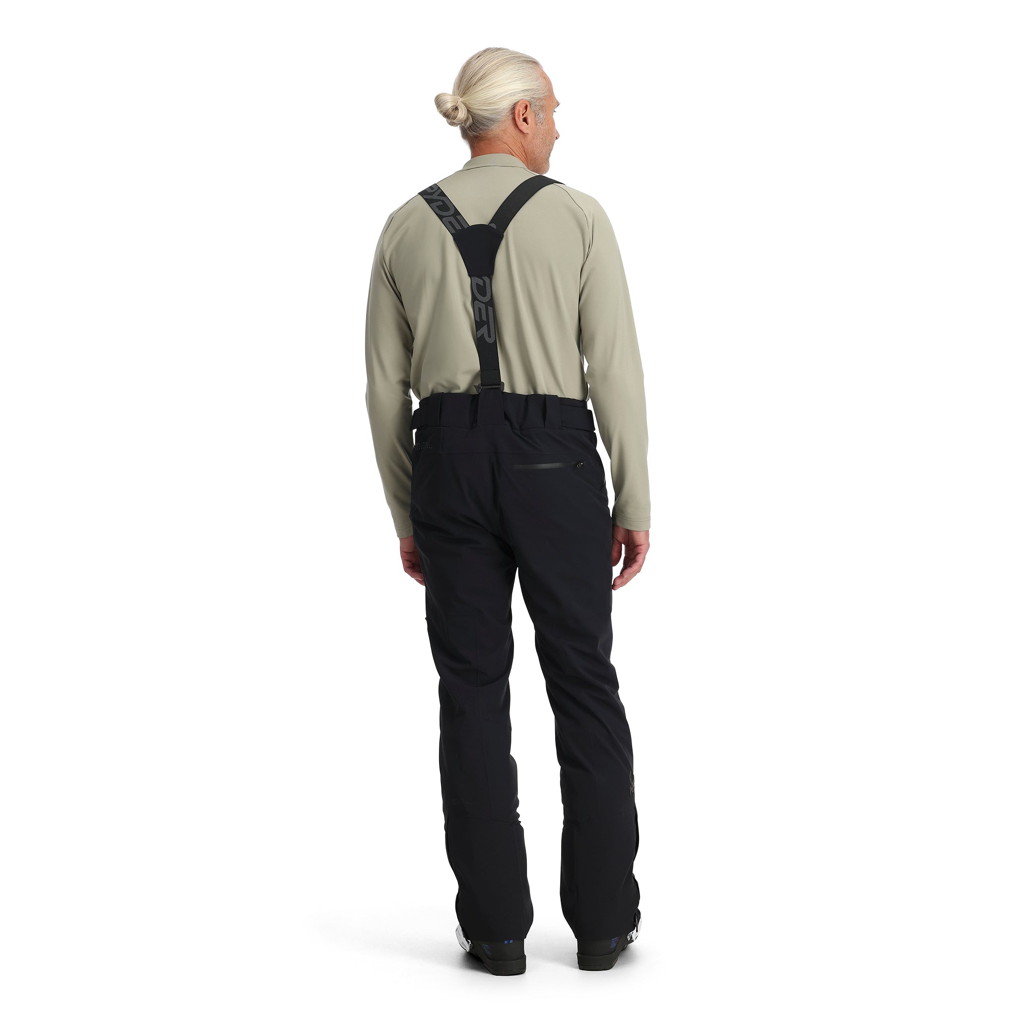 A man wearing a pair of black Spyder Bormio Ski Pants, which are waterproof, breathable, stretchable, and warm.