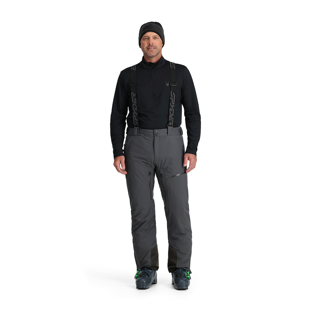 A man wearing a pair of grey Spyder Men's Dare Ski Pants that are waterproof, insulated, breathable, and stretchable.