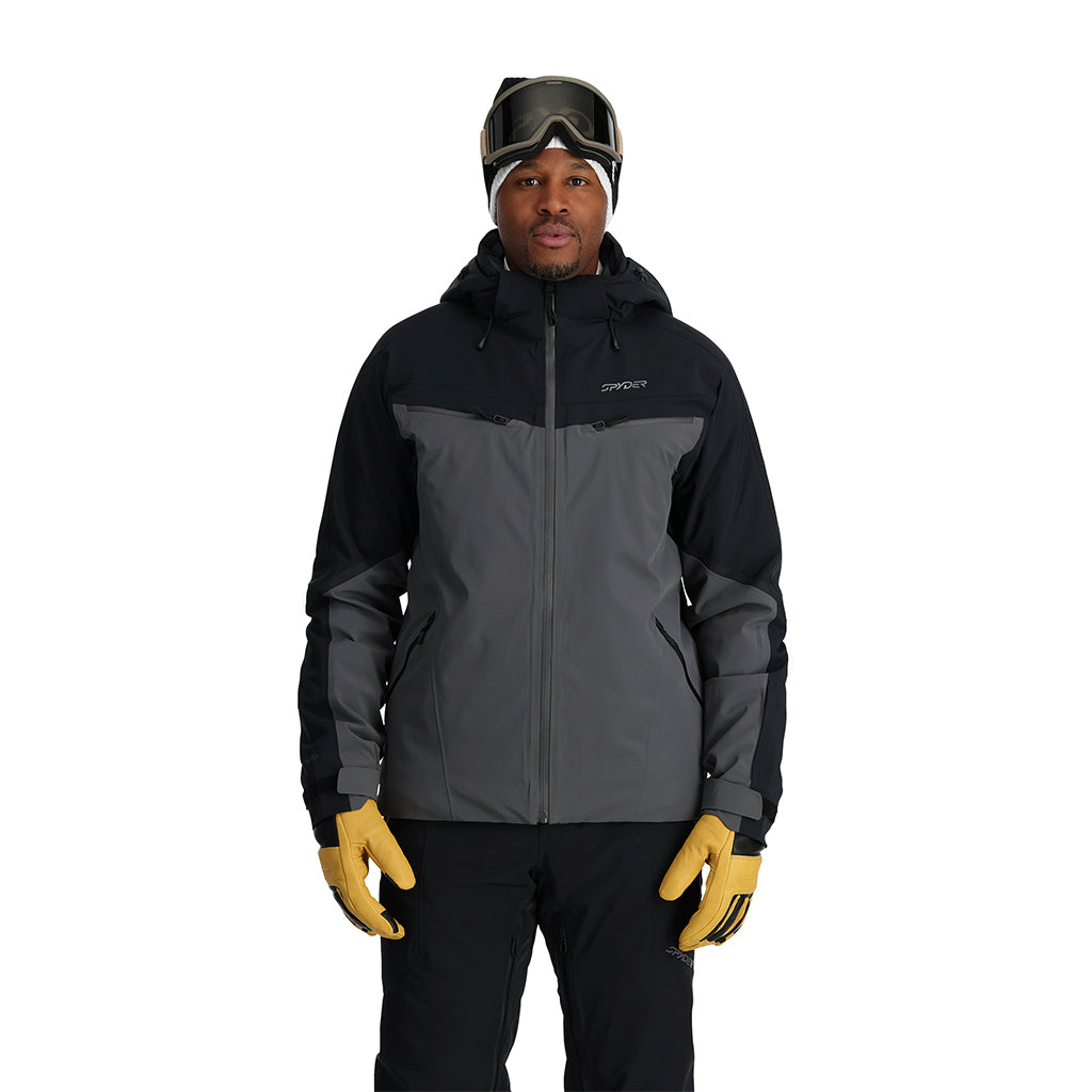 A man wearing a grey and black Spyder Men's Monterosa Ski Jacket that is waterproof, breathable, stretchable, and insulated.