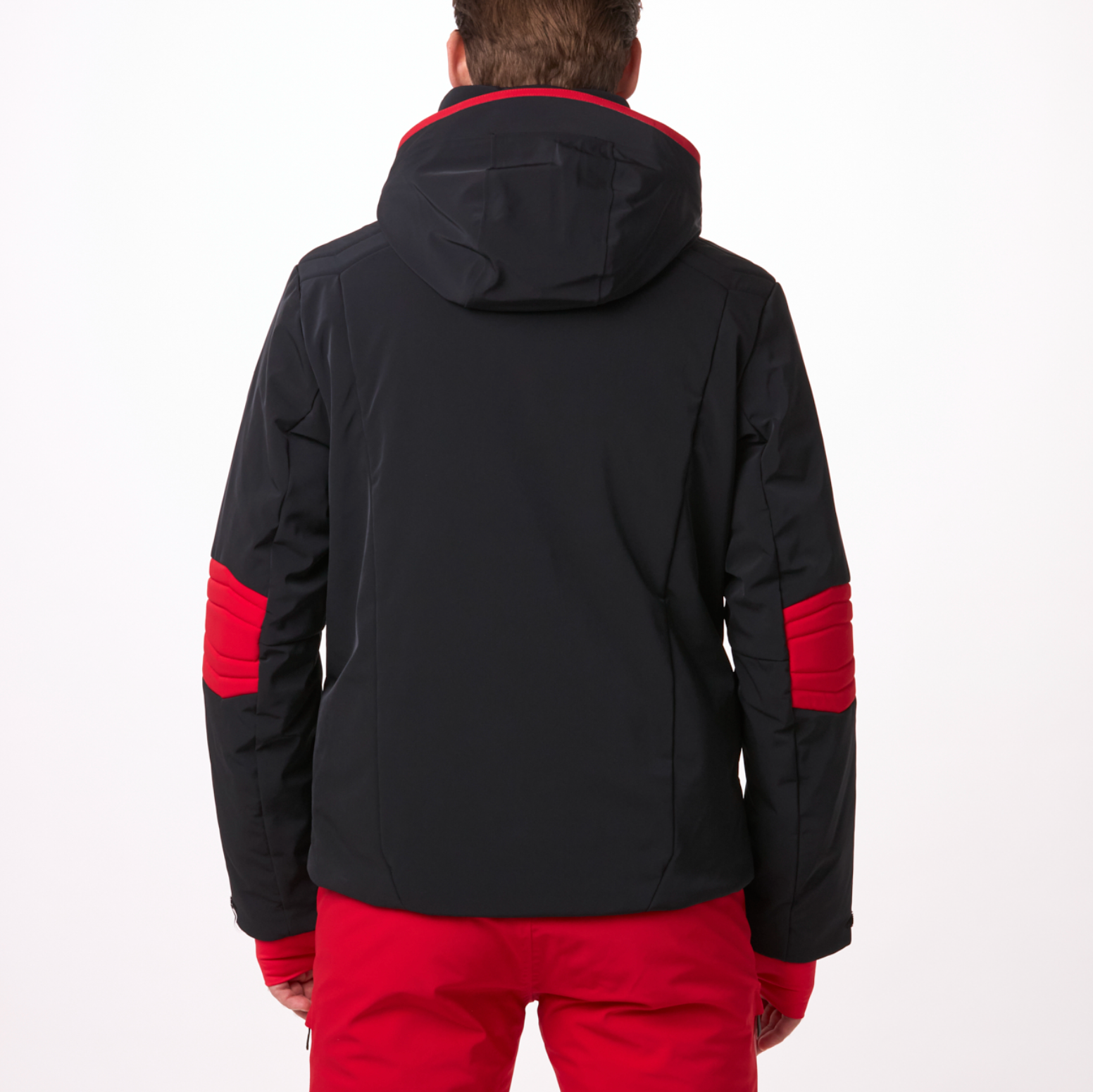 A man wearing a black and red Toni Sailer Men's Matti Ski Jacket made from premium fabrics and insulation that is waterproof, breathable, stretchable, insulated, and fashionable.