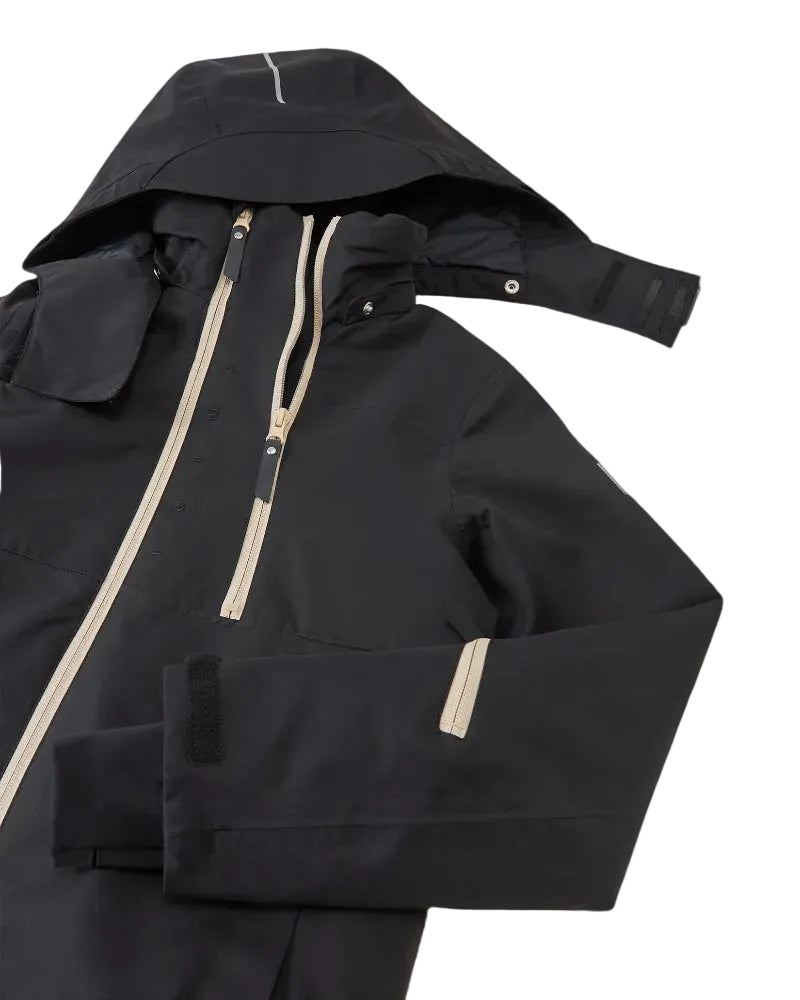 Front view of a black Reima Jr Tieten Jacket featuring a waterproof Reimatec shell, detachable safety hood, zipped sleeve ski pass pocket, and full front zipper storm flap.
