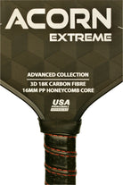An ACORN EXTREME pickleball paddle with a black and gray geometric pattern on the surface, approved by USA Pickleball, with red and black handle.