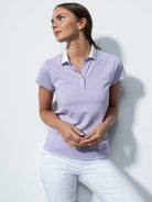A woman wearing a purple Daily Sports Women's Candy Caps Polo Shirt on a white background