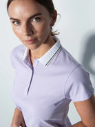 A woman wearing a purple Daily Sports Women's Candy Caps Polo Shirt on a white background