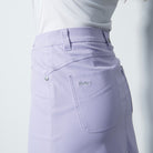 A woman wearing a purple Daily Sports Women's Lyric 18" Golf Skort on a white background
