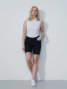 A woman wering a pair of black Daily Sports Women's Lyric 19" Golf Shorts on a white background