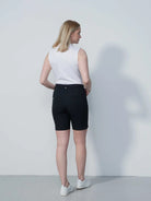 A woman wering a pair of black Daily Sports Women's Lyric 19" Golf Shorts on a white background