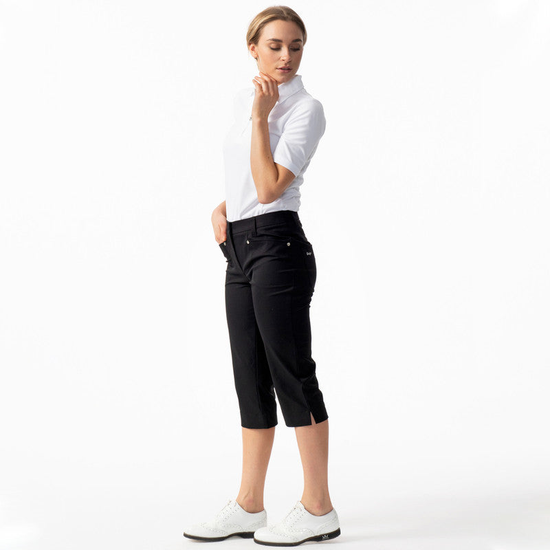 A woman wearing black Daily Sports Women’s Lyric 29" Golf Capris on a white background