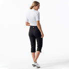 A woman wearing black Daily Sports Women’s Lyric 29" Golf Capris on a white background