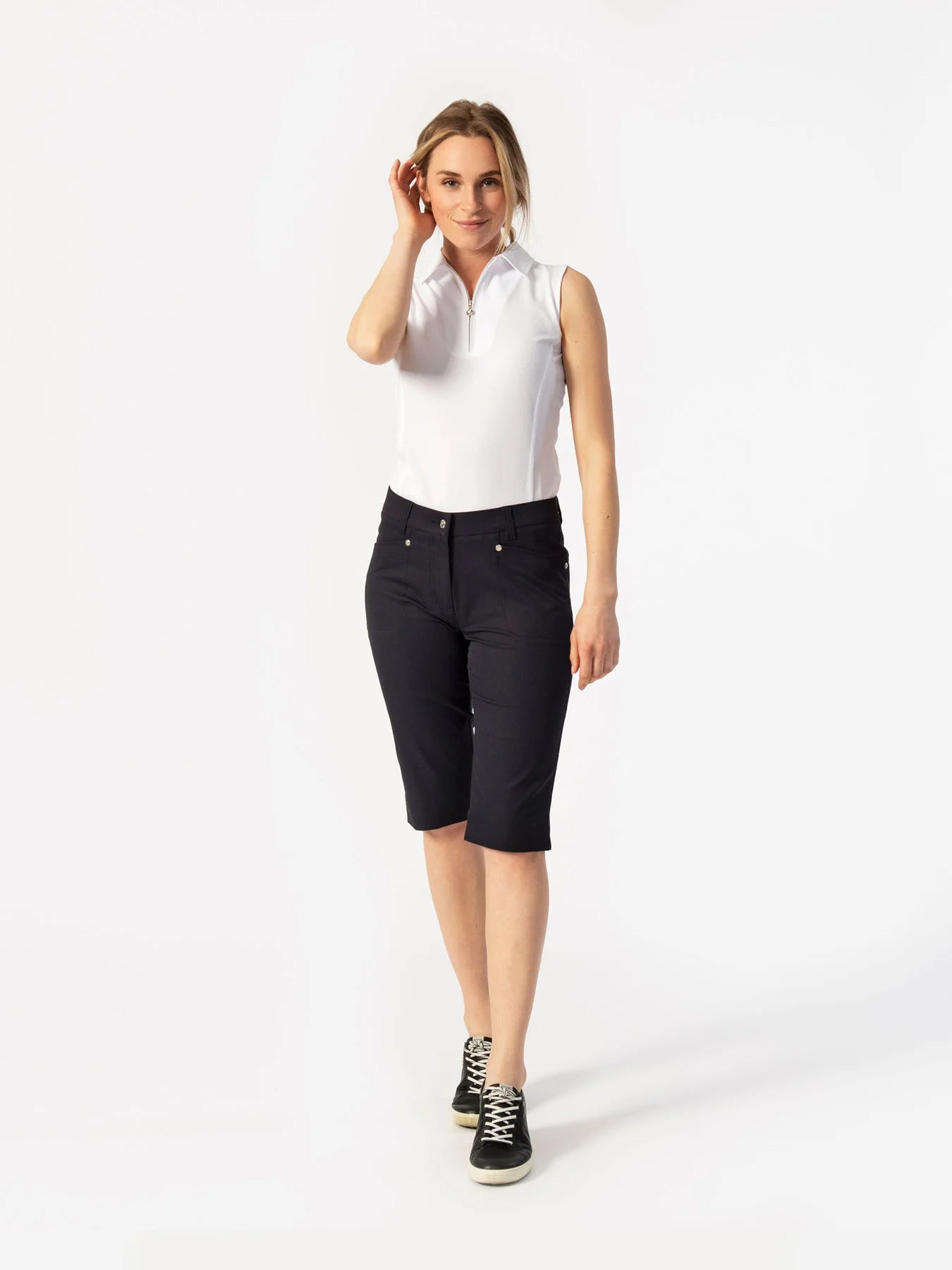 A woman wearing pair of black Daily Sports Women's Lyric City Shorts on a white background