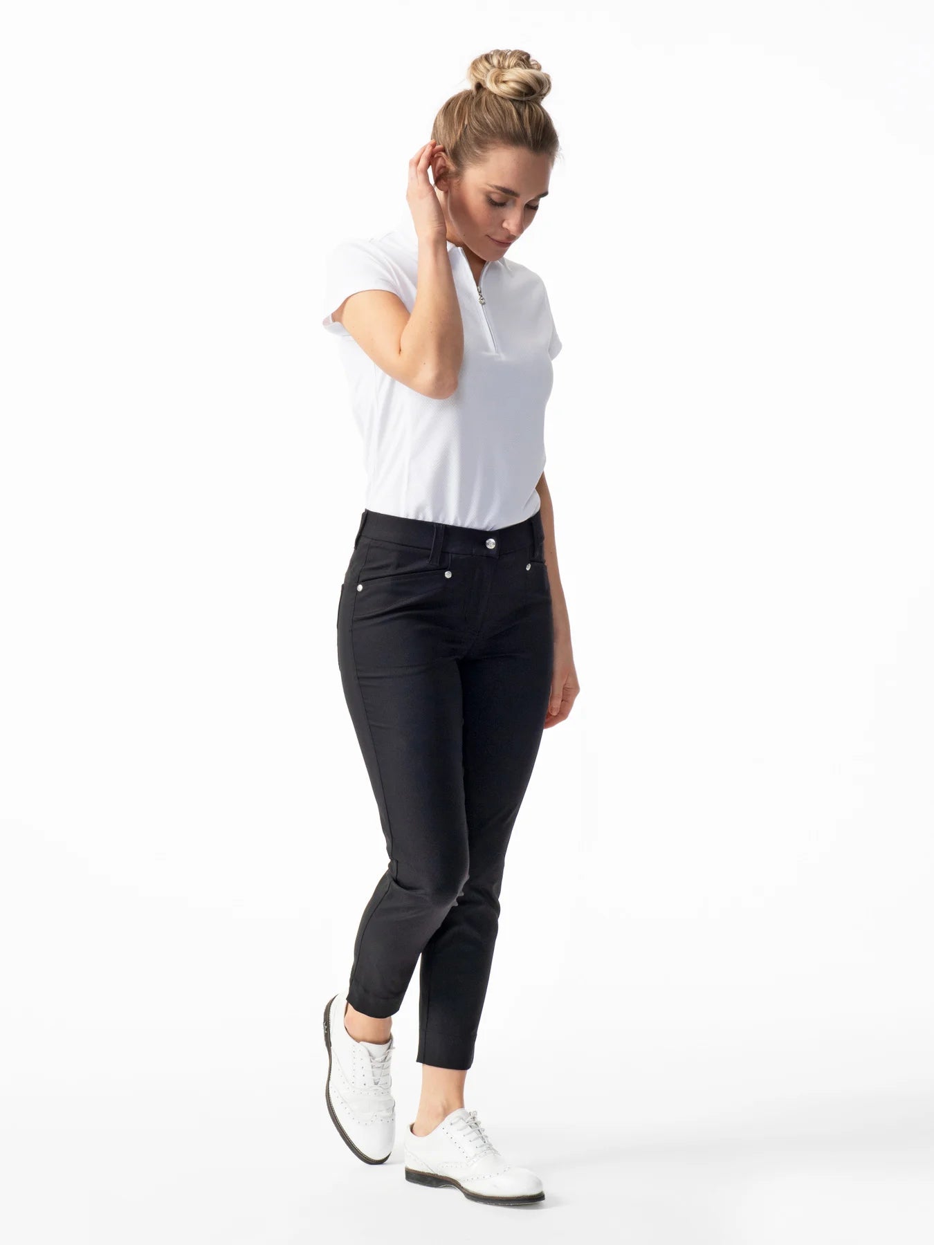 A woman wearing a pair of black Daily Sports Women’s Lyric High Water Golf Pants on a white background