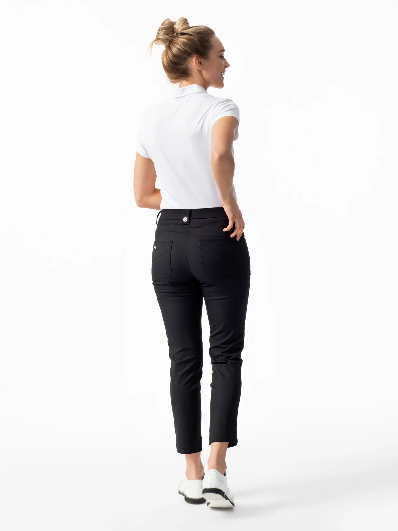 A woman wearing a pair of black Daily Sports Women’s Lyric High Water Golf Pants on a white background