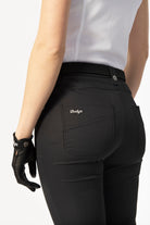 A woman wearing a pair of black Daily Sports Women’s Lyric High Water Golf Pants on a white background