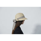 A woman wearing a Daily Sports Trento straw hat with a contrasting band and a bow detail on the side.