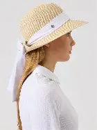A woman wearing a Daily Sports Trento straw hat with a contrasting band and a bow detail on the side.