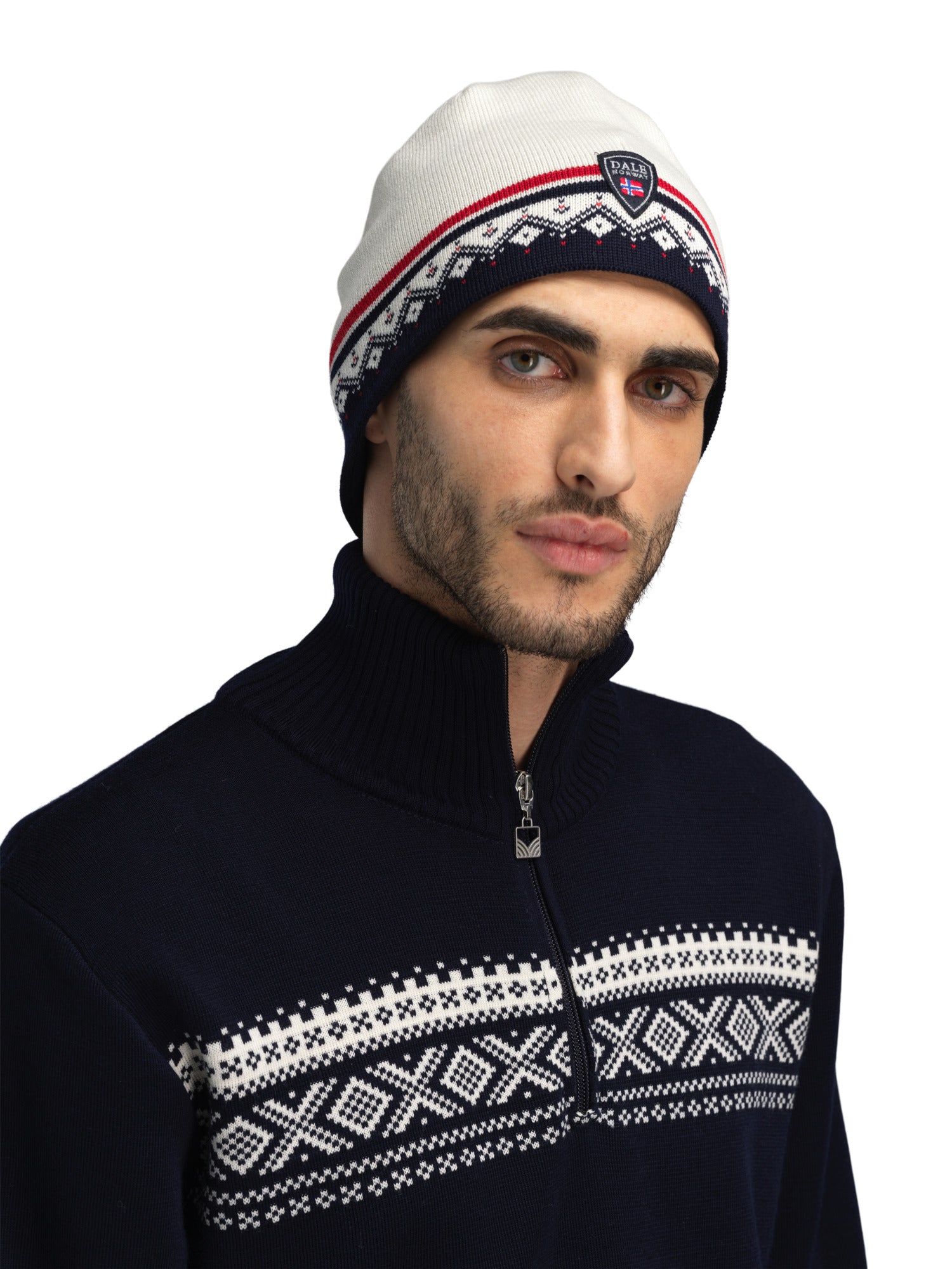 A man wearing an off-white and navy Dale of Norway Moritz Hat that is made in Norway from luxurious Norweigan wool.