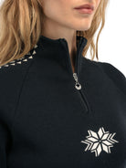 A close-up of a woman wearing a black Dale of Norway Women’s Geilo turtleneck sweater made in Norway from luxurious Norweigan merino wool.