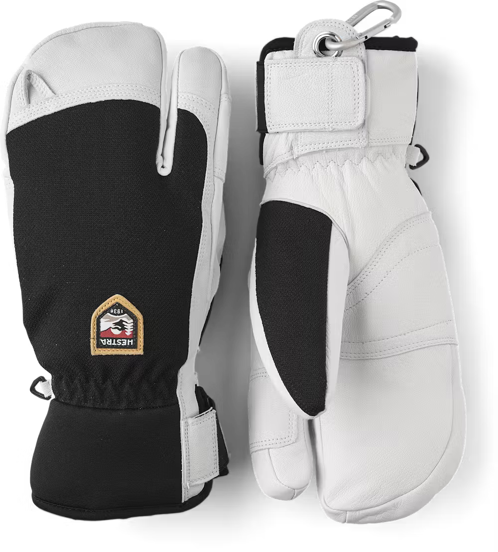 A pair of black and white Hestra Army Leather Patrol 3 Finger gloves, which are designed to keep your hands warm and dry in harsh winter conditions.