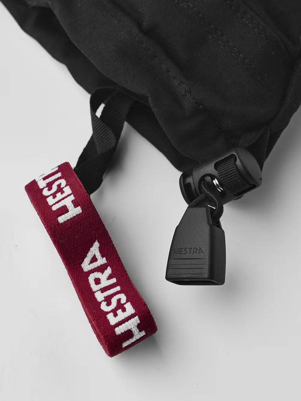 A close-up of the wrist of a black and white Hestra Junior Army Leather Heli Ski Mitten that is made from premium leather.