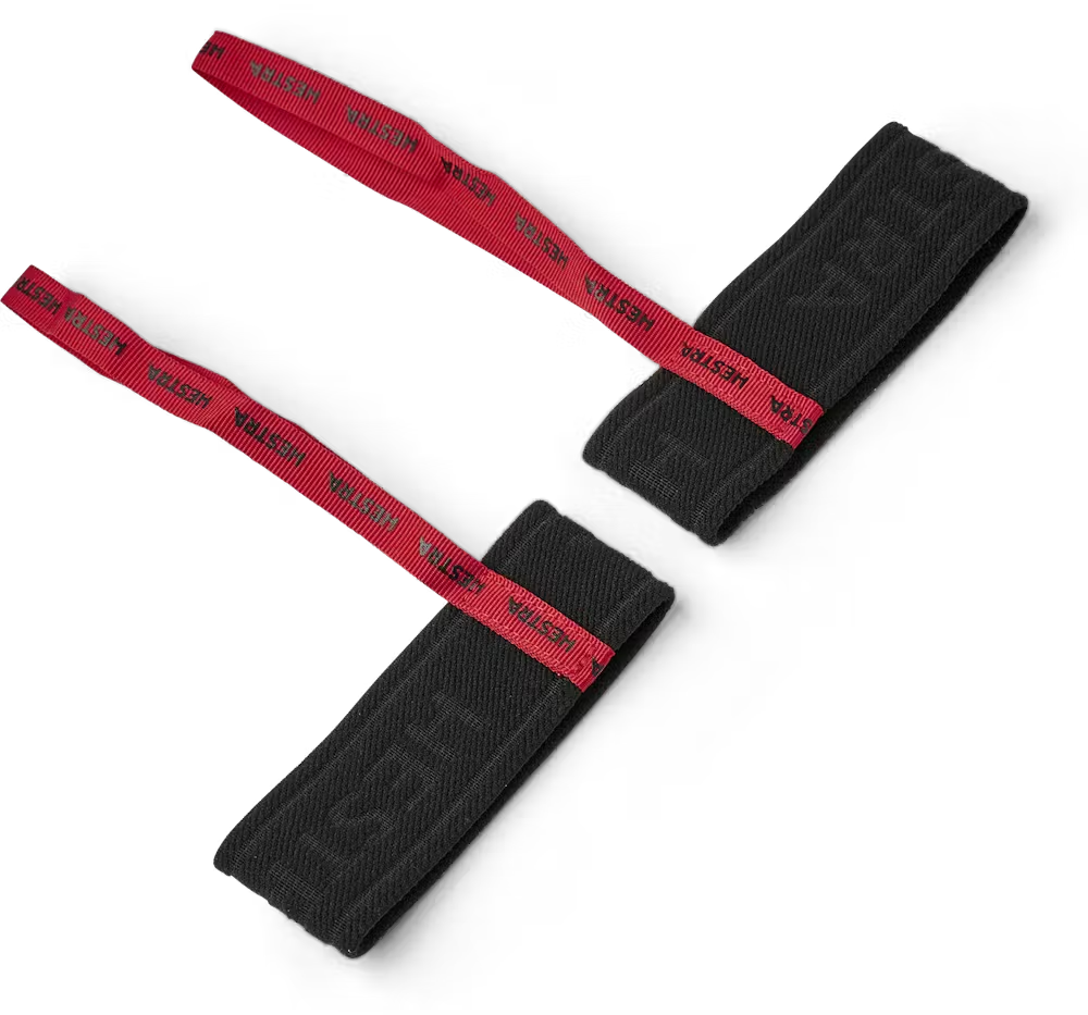 A pair of red and black HESTRA men's handcuffs designed to attach to ski and snowboard gloves.