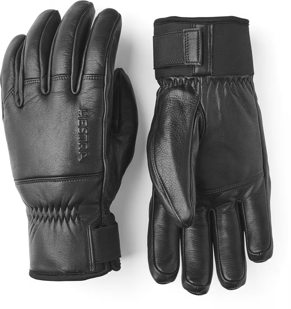 A pair of black leather Hestra Omni Gloves that are designed to keep your hands warm and dry in harsh winter conditions.