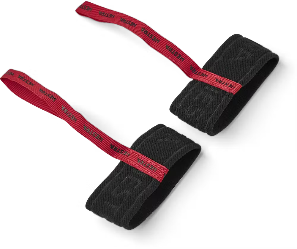 A pair of red and black HESTRA women's handcuffs designed to attach to ski or snowboard gloves.