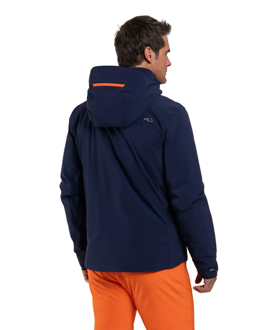 Rear view of a navy Kjus Men’s Cirque Jacket featuring 4-way stretch waterproof fabric, zoned down insulation, water-repellent zippers, AC-Vent forearm ports, and a detachable helmet-compatible hood.