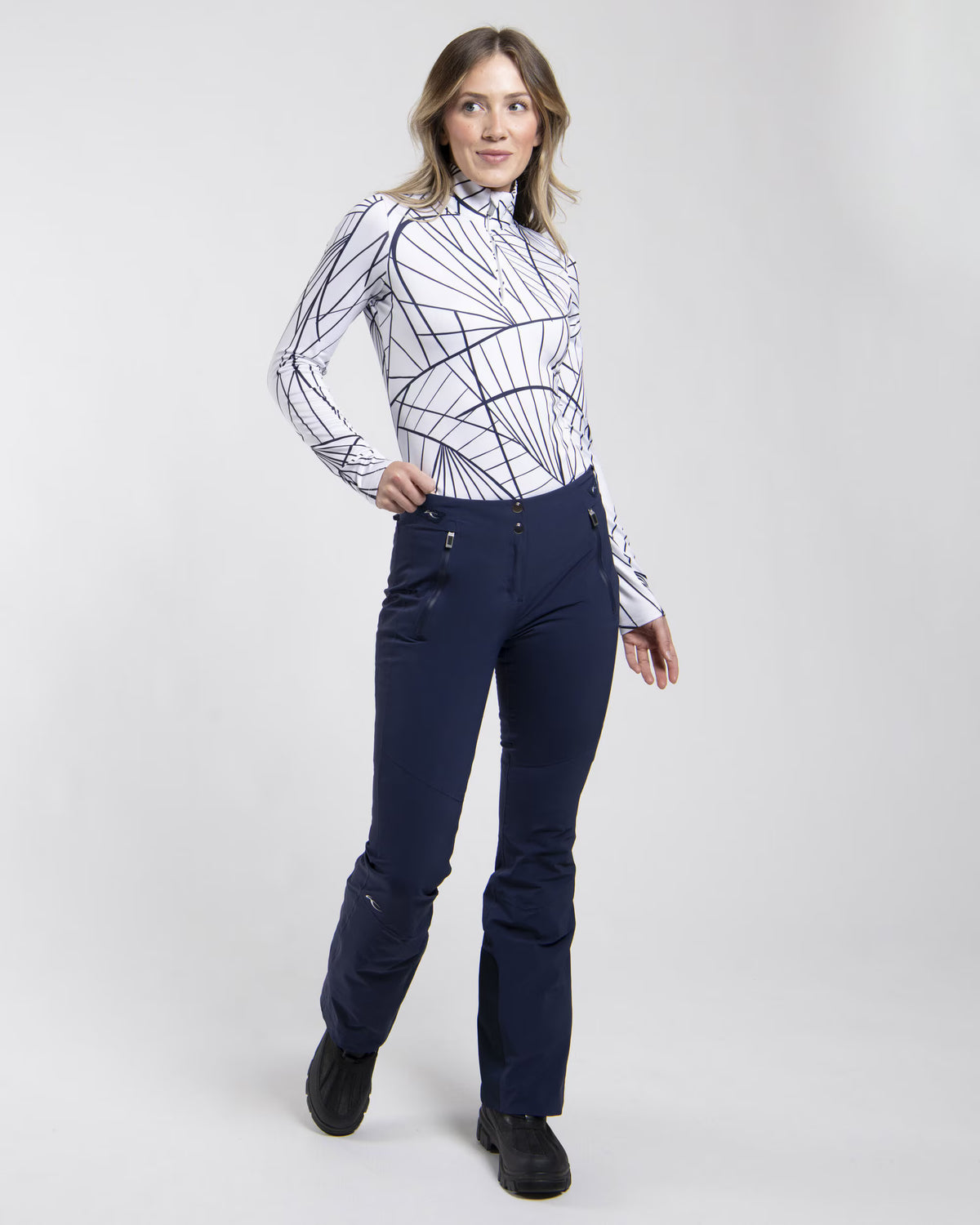 Front view of black Kjus Women’s Formula Pants featuring 4-way stretch waterproof fabric, Fast Thermo Core insulation, water-repellent zippers, and Schoeller Keprotec reinforced scuff guards.