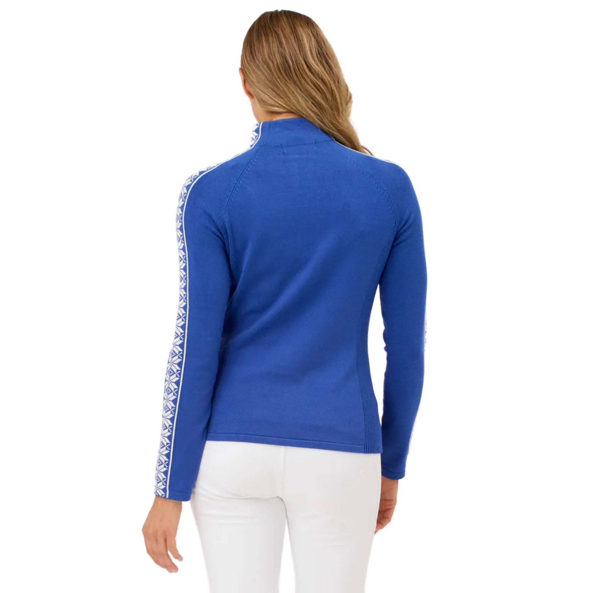 A woman wearing a blue Krimson Klover Women's Slalom Zip Neck Sweater with white snowflake jacquard sleeve details and a quarter zip front.