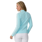 A woman wearing a light blue Krimson Klover Women's Slalom Zip Neck Sweater with white snowflake jacquard sleeve details and a quarter zip front.