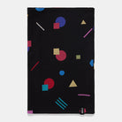 A black Le Bent Kids' Confetti Midweight Neck Gaiter that features a colourful geometric pattern.