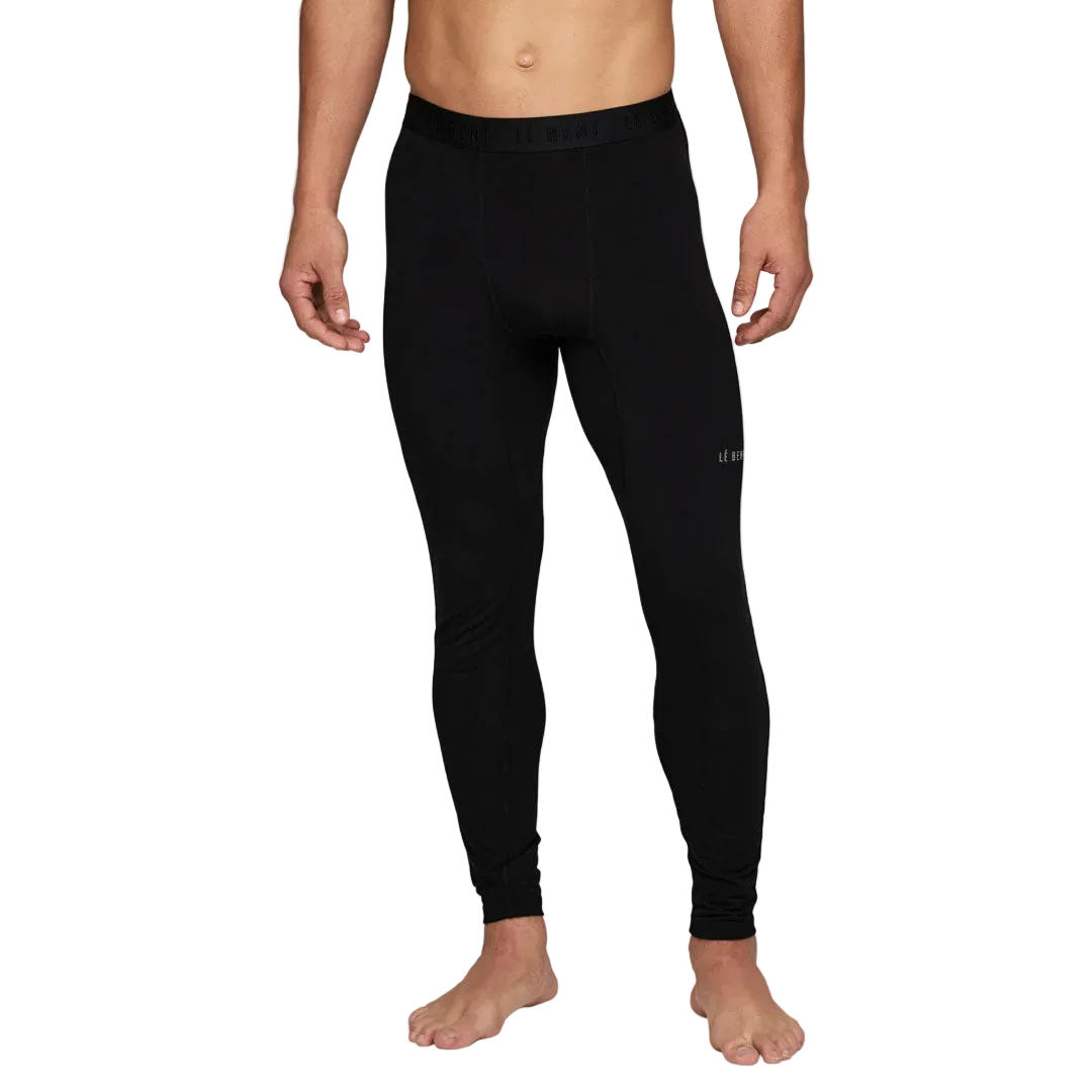 A man wearing a pair of Le Bent Men's Core Midweight Baselayer Bottoms that are made with a bamboo and merino wool blend.