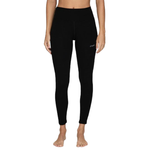 A woman wearing a pair of black Le Bent Women's Core Midweight Baselayer Bottoms that are made from a bamboo and merino wool blend.