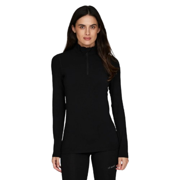 A woman wearing a black Le Bent Women's Midweight 1/4 Zip Turtleneck baselayer top that is made from a stretchable, breathable, premium bamboo and merino wool blend.